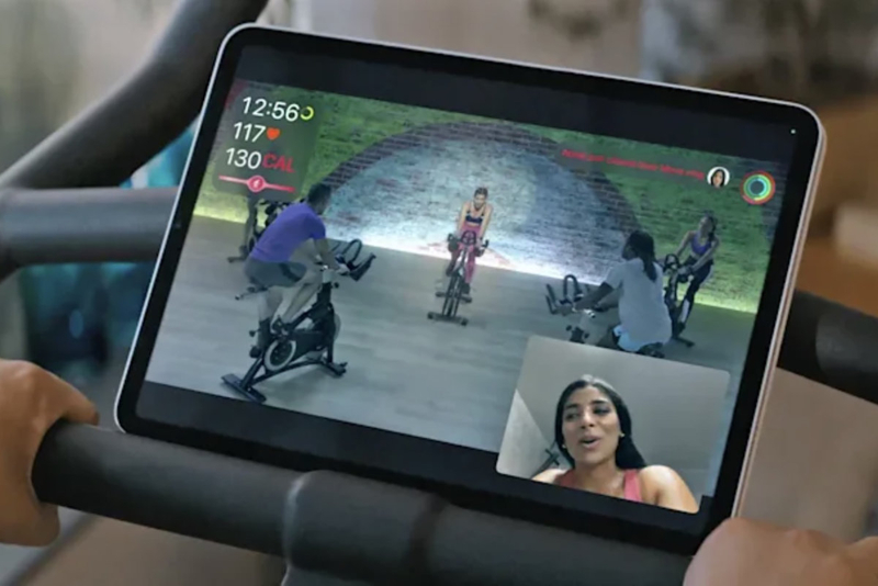 Frau über Facetime sichtbar, Tablet vom Cyclingrad zeigt Trainingsvideo